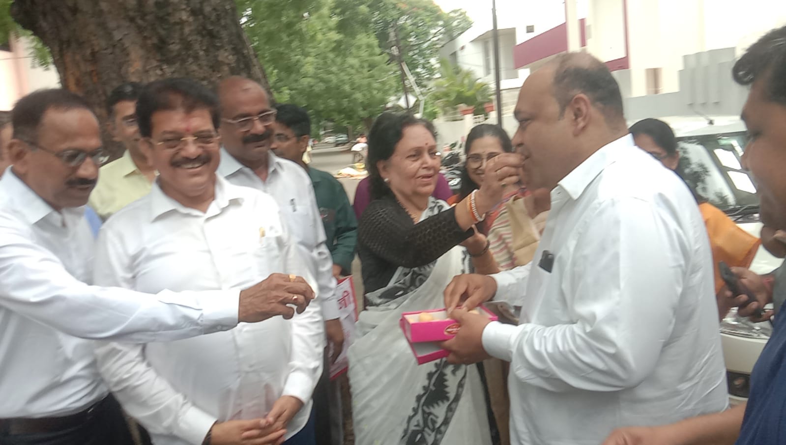 एकमेकांना पेढे भरवतांना मित्र परिवार